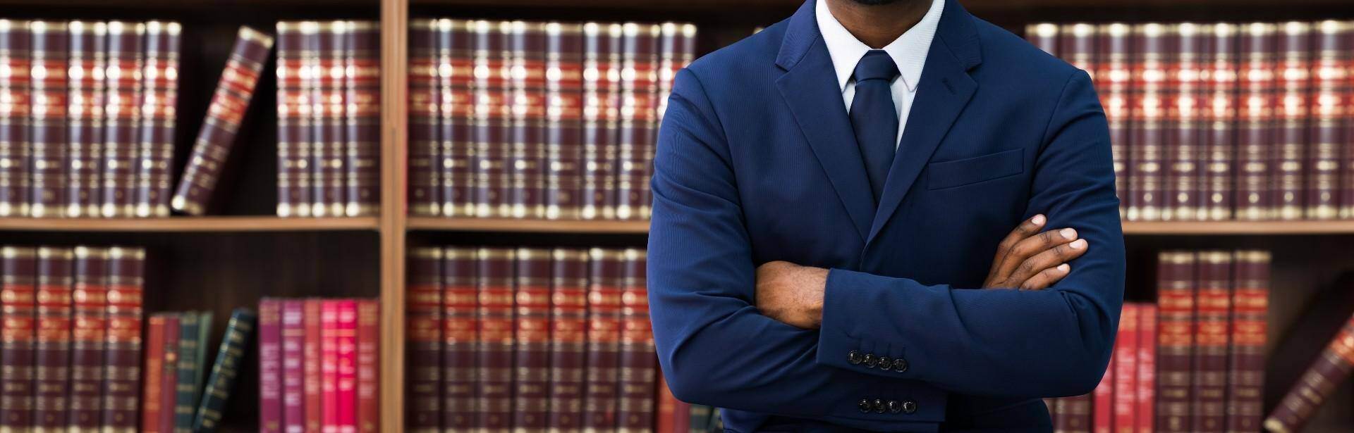 A black lawyer standing in front of a bookshelf of law book in Acworth, Georgia