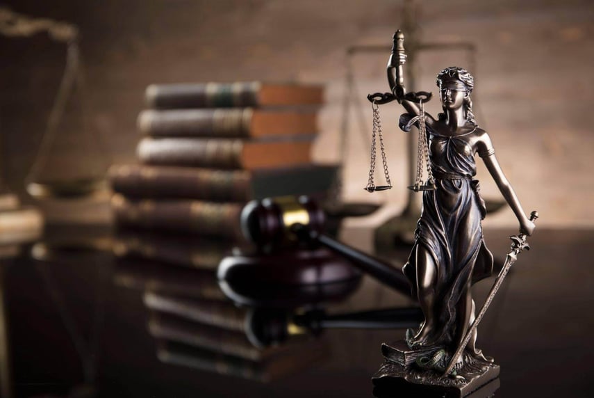 A statue of a woman holding a balance, a stack of books, and a gavel on a table in Atlanta, Georgia