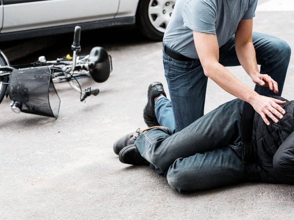 Man assisting another individual injured in a motor vehicle accident